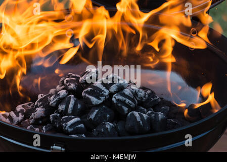 Close-up of barbecue fosse avec rougeoyant et flaming hot les briquettes de charbon, de l'alimentation arrière-plan ou la texture. Banque D'Images