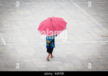 Fille hmong avec grand parapluie rouge à Sa Pa, Lao Cai, Vietnam Banque D'Images