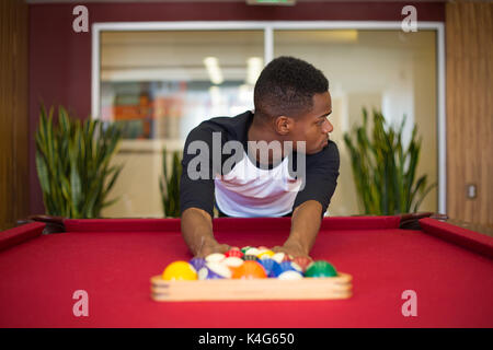 Closeup portrait, jeune homme sortir, jouer au billard à la table de billard, isolé à l'intérieur arrière-plan Banque D'Images