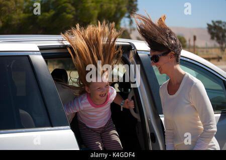 Une mère et sa fille de l'expérience des vents forts à côté de leur véhicule dans le centre de la californie Banque D'Images