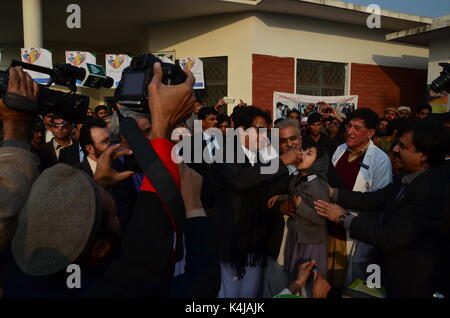 Imran Khan, chef de la polio administre PTI chute à un enfant à Islamabad au Pakistan avec le Ministre en chef du KPK Pervez Khattak et Jahangir Tareen. Banque D'Images