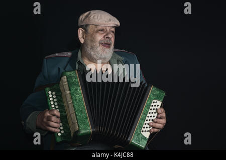 Beau portrait (discrète) d'un ancien militaire à la retraite, l'homme chanter tout en jouant accordéon Banque D'Images