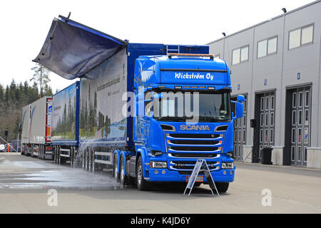 Laukaa, Finlande - le 19 mai 2017 : le pilote soulève le toit de Scania r730 camion-remorque à copeaux de bois à l'eau de pluie recueillies lors de vidage. Banque D'Images