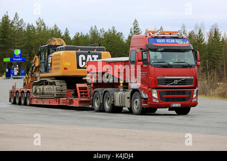 Mikkeli, Finlande - 17 mai 2017 : Volvo fh semi s'apprête à transporter un chat 336fl grand pelle sur chenilles hydraulique sur remorque à col de cygne à un arrêt de camion. Banque D'Images