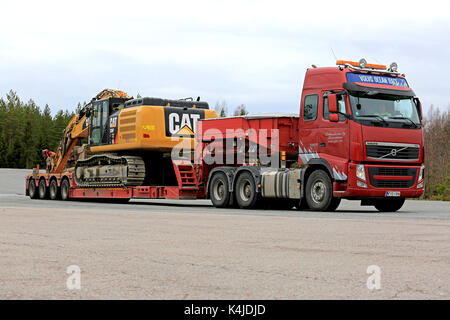 Mikkeli, Finlande - 17 mai 2017 : Volvo fh semi s'apprête à transporter un chat 336fl grand pelle sur chenilles hydraulique sur remorque à col de cygne à un arrêt de camion. Banque D'Images