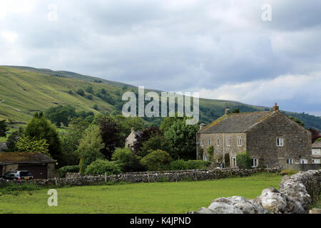 Ferme en pierre traditionnelle avec terrain et burnsall moor dans l'arrière-plan à partir de la voie du milieu à kettlewell, Yorkshire Dales, North Yorkshire, Angleterre Banque D'Images