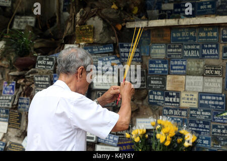 Homme priant en copie de la grotte de Massabielle, église Saint-Philippe (église Huyen Sy), Ho Chi Minh ville, Vietnam, Indochine, Asie du Sud-est, Asie Banque D'Images