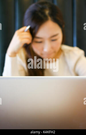Portrait d'un asian woman using laptop in a cafe Banque D'Images