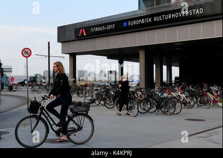 Femme sur un vélo à l'extérieur Dokk1, une nouvelle culture et multimédia maison à Aarhus, Danemark. Banque D'Images