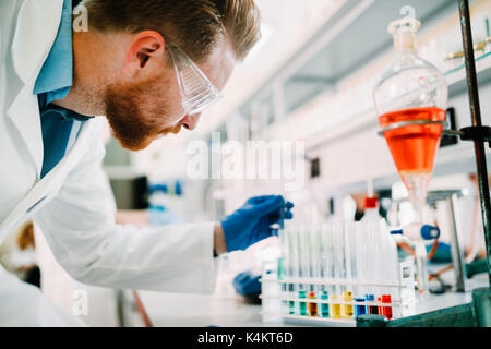 Beau étudiant en chimie working in laboratory Banque D'Images