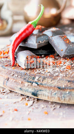 Morceaux de chocolat avec des piments sur une table en bois, d'épices, selective focus Banque D'Images