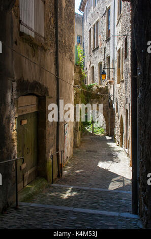 Une ruelle étroite typique dans la ville de Montélimar en France avec de grands édifices en pierre et des portes avec des ombres Banque D'Images