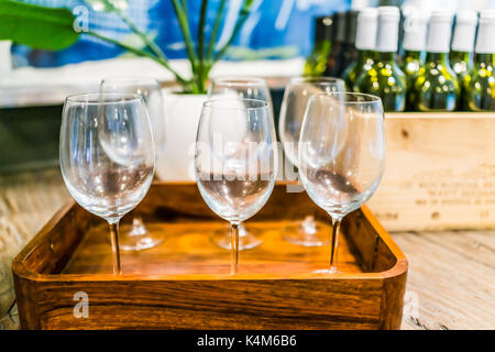 Gros plan du vide des verres à vin sur plateau avec des caisses en bois de bouteilles sur la table dans la chambre Banque D'Images
