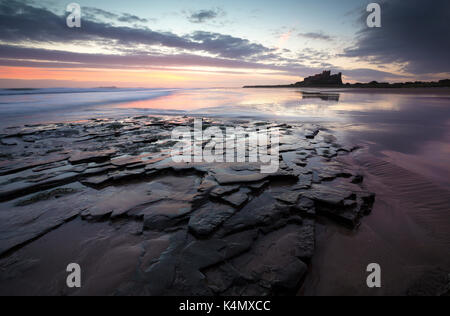 Vue vers le château de bamburgh au lever du soleil à partir de la plage de bamburgh, bamburgh, Northumberland, Angleterre, Royaume-Uni, Europe Banque D'Images