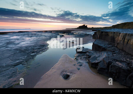 Vue vers le château de bamburgh au lever du soleil à partir de la plage de bamburgh, bamburgh, Northumberland, Angleterre, Royaume-Uni, Europe Banque D'Images