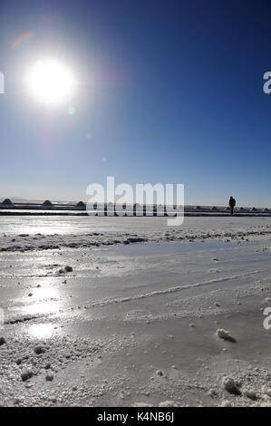 Un homme qui marche par quelques cônes de sel dans les salines à Uyuni, Bolivie Banque D'Images