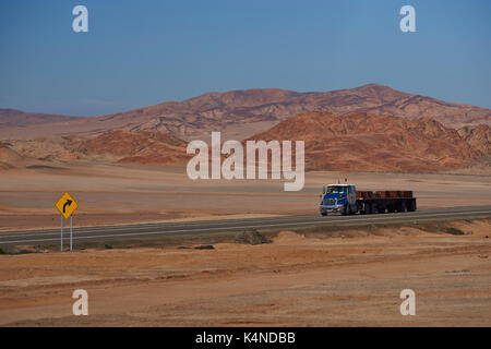 Camion transportant des plaques de cuivre sur la route panaméricaine qui traverse le paysage aride et rude de l'Atacama au nord du Chili. Banque D'Images