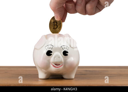 Pièce d'or d'être inséré dans piggy bank Banque D'Images