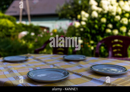 Petites plaques sur une table avec vue sur le jardin à l'arrière-plan. Banque D'Images