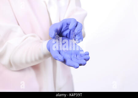 Gros plan des mains de médecins dans les gants en silicone protège dents holding. Banque D'Images