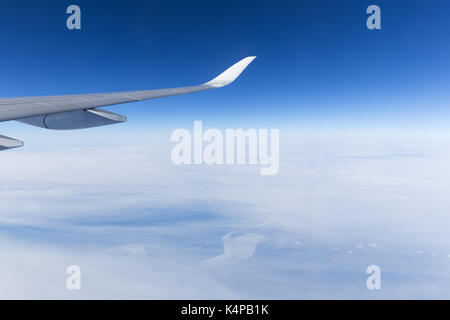 Avis de bleu ciel clair et aile d'avion au-dessus des nuages dans la lumière du jour. Banque D'Images