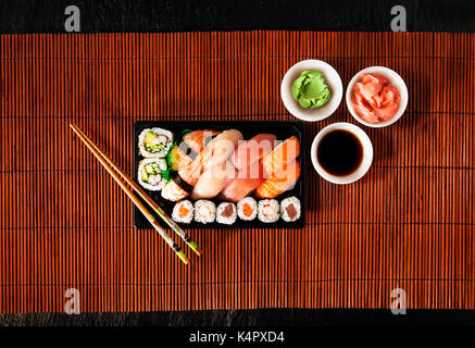 Set de sushis nigiri gunkan, rouleaux et servi sur un tapis de bambou Banque D'Images