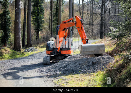 Mini pelle posant du gravier neuf et réparant un chemin sur le chemin de Montpelier Hill, Hell Fire Club, Dublin, Irlande Banque D'Images