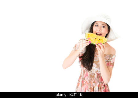 Cheerful belle fille portant des vêtements robe d'été l'article sur fond blanc et à la caméra à manger la pastèque. Banque D'Images