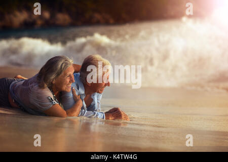 Portrait of a senior couple lying on beach Banque D'Images