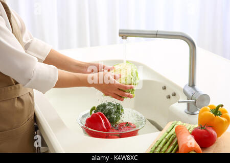 Femme japonaise laver les légumes dans la cuisine Banque D'Images