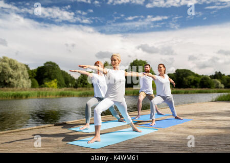 Groupe de personnes faisant des exercices de yoga en plein air Banque D'Images