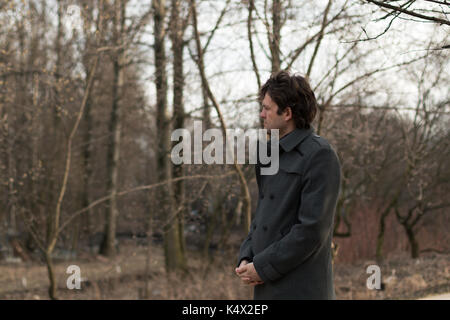 Portrait d'un jeune homme séduisant triste à gauche dans le parc, la forêt en automne ou au printemps. portrait sur la nature du parc, les bois, sur les Banque D'Images