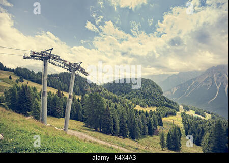 Paysage de montagne avec des forêts, dolomites, valley et télésiège en été. ciel avec nuages. photos avec filtre effet vintage. Banque D'Images