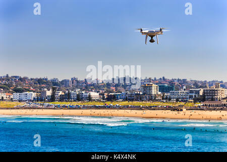 Quadrocopter de vol sur la ligne de sable de la célèbre plage de Bondi à Sydney en Australie. gens actifs natation, surf et détente dans l'iconique gam Banque D'Images