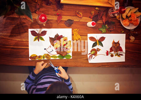 Mon petit enfant, garçon, l'application quitte en utilisant la colle tout en le faisant à l'école des arts et métiers, autumntime Banque D'Images