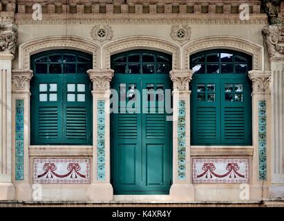 Singapour extérieur de maison boutique traditionnelle avec fenêtres en bois vert et les majorquines dans le quartier historique de Little India. Banque D'Images