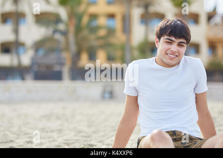 Portrait avant de young happy man relaxing on beach Banque D'Images