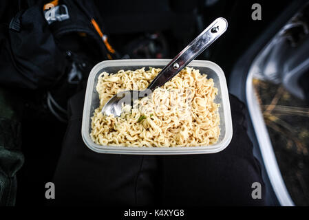 Soupe instantanée avec des nouilles dans un récipient en plastique avec une cuillère, extérieur. Banque D'Images