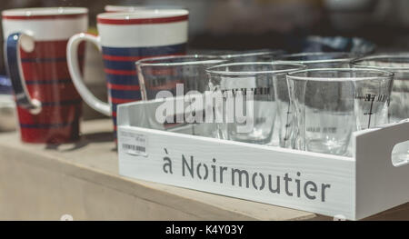 NOIRMOUTIER, FRANCE - Juillet 03, 2017 : Gros plan d'une fenêtre d'une boutique de souvenirs avec des lunettes, le plateau et tasses Banque D'Images