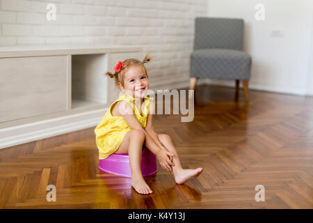 Petite fille sur le pot dans la chambre Banque D'Images