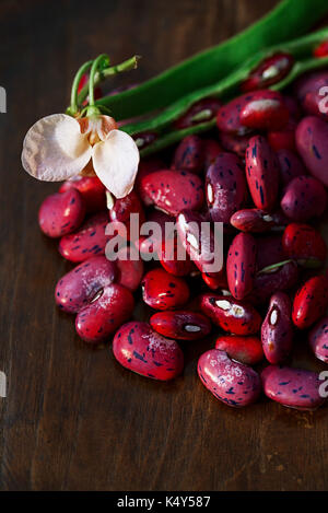 Scarlet exécutant les haricots - pod, fleur et haricots sur table en bois Banque D'Images