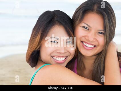 Digital composite de Best Friends hugging contre plage floue Banque D'Images