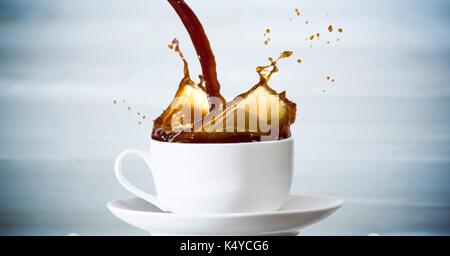Digital composite de café est versé dans white cup contre panneau bleu flou Banque D'Images
