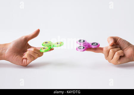 Close up de deux mains jouant avec fidget spinners Banque D'Images