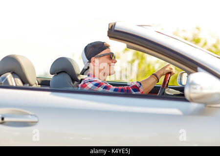 Heureux jeune homme dans des tons driving convertible car Banque D'Images