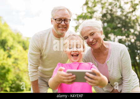 Les cadres supérieurs des grands-parents et petite-fille selfies Banque D'Images