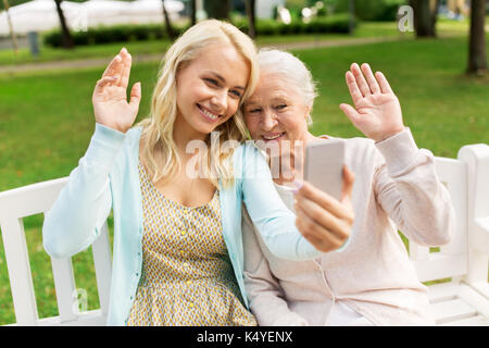 Fille et mère senior en tenant à selfies park Banque D'Images