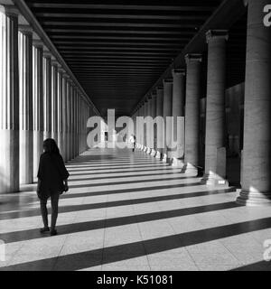 Athènes, Grèce - 14 octobre 2015 : les gens de la stoa attalos à l'ancienne agora. L'ombre et la lumière à travers des colonnes de marbre abstrait architecture noir un Banque D'Images