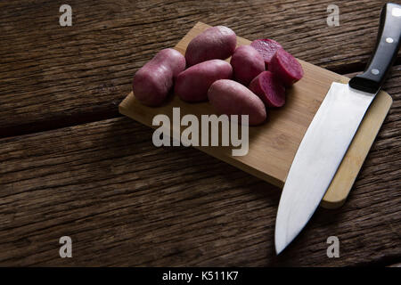 Close-up de patates douces et d'un couteau sur une planche à découper Banque D'Images