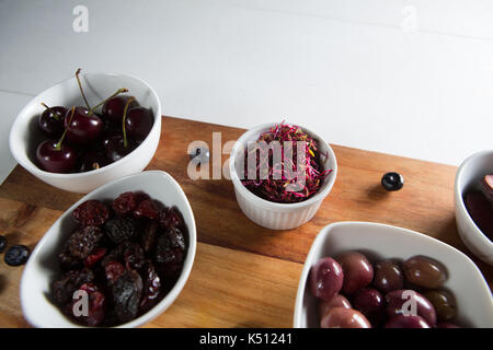 Close-up of olives avec divers fruits dans un bol sur une planche à découper sur le tableau Banque D'Images